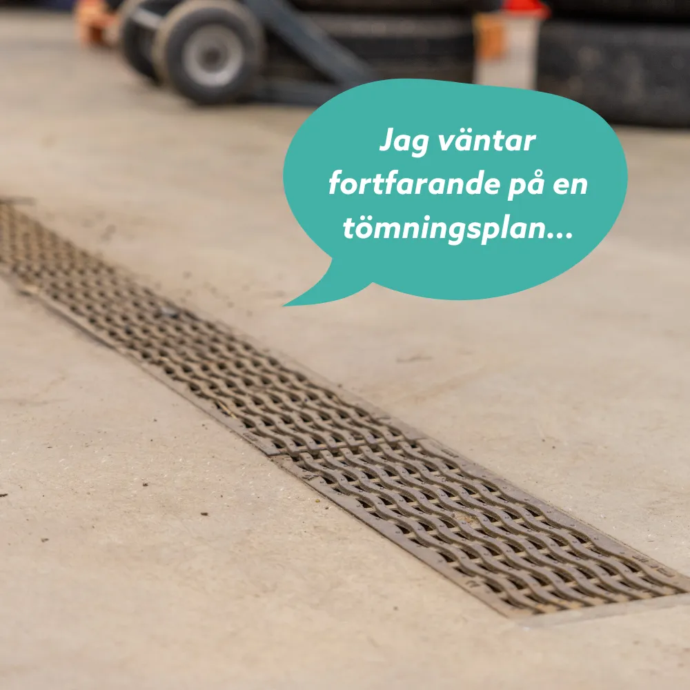 Tvättränna i metall med en pratbubbla på svenska som säger "Jag väntar fortfarande på en tömningsplan...", placerad i en verkstads- eller garagemiljö.