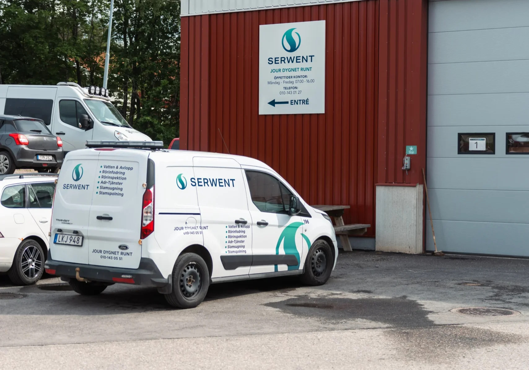 Serwent Gävle En vit skåpbil med Serwent Gävle som varumärke står parkerad utanför en röd industribyggnad med en Serwent-skylt och ordet Entré ovanför entrén. Andra fordon och träd syns i bakgrunden.