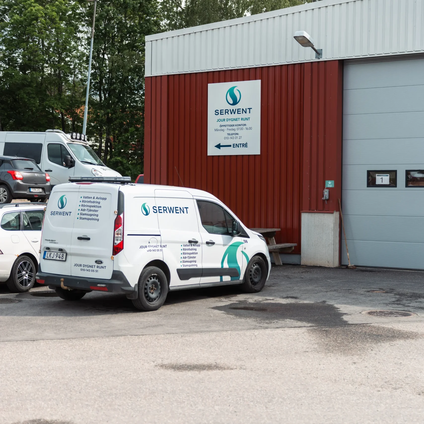Serwent Gävle En vit skåpbil med Serwent Gävle som varumärke står parkerad utanför en röd industribyggnad med en Serwent-skylt och ordet Entré ovanför entrén. Andra fordon och träd syns i bakgrunden.
